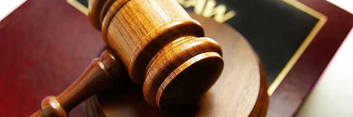 A wooden gavel sitting on top of a law book