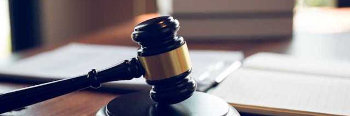 A wooden judge's gavel on a wooden desk