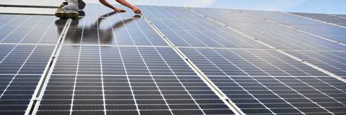 A worker installing solar panels on a roof