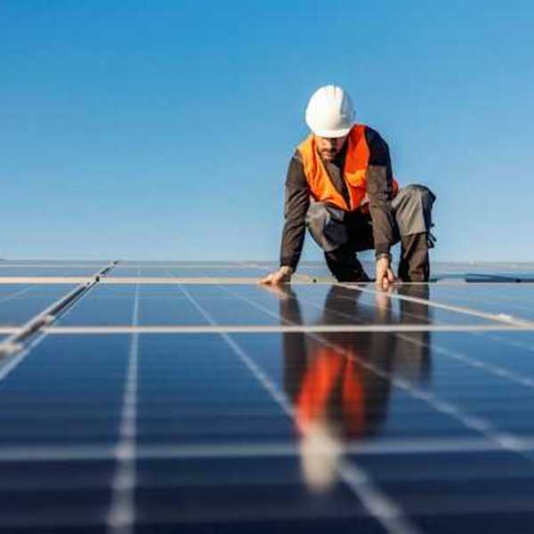 A worker installing solar panels on a roof