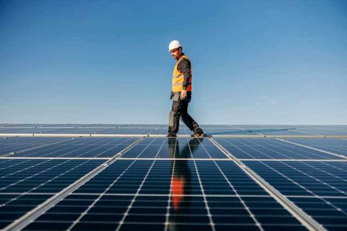 A worker walking among solar panels