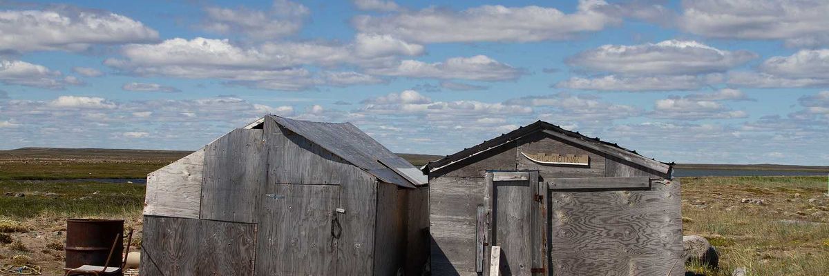 Abandoned buildings on a bare arctic summer landscape
