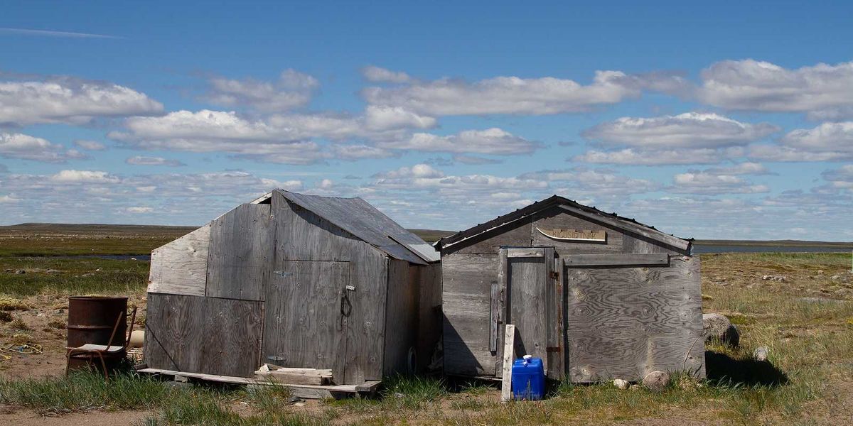 Abandoned buildings on a bare arctic summer landscape