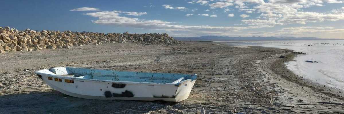 Abandoned derelict rowboat beached on the shore of the Salton Sea