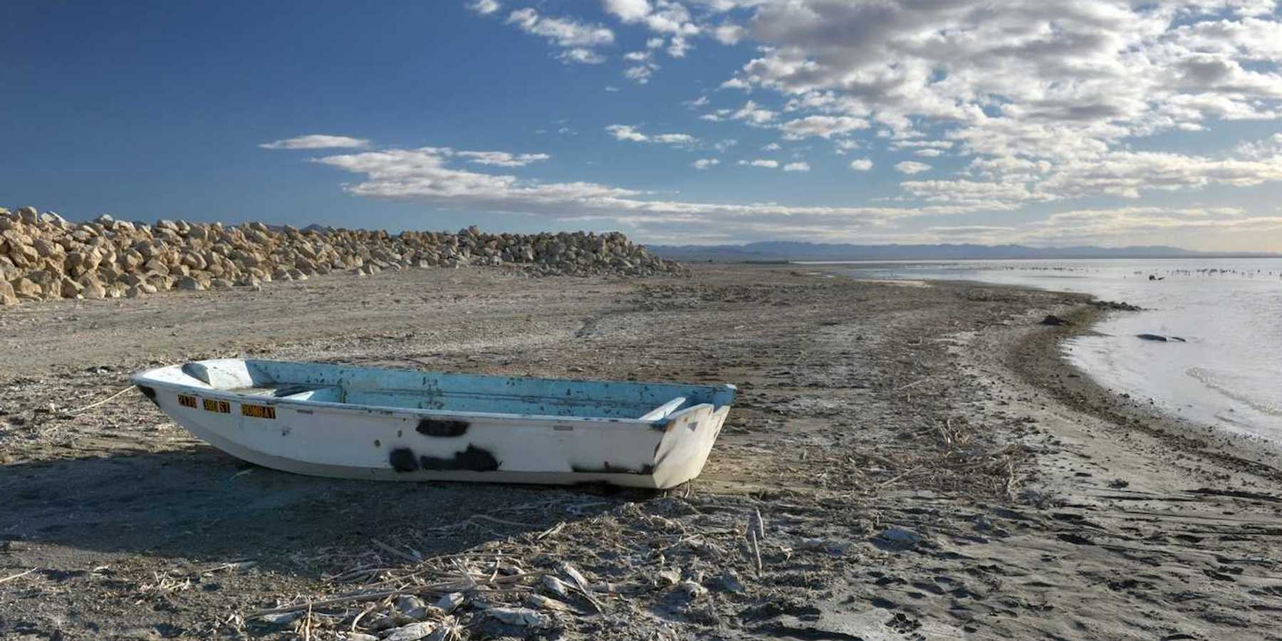 Abandoned derelict rowboat beached on the shore of the Salton Sea