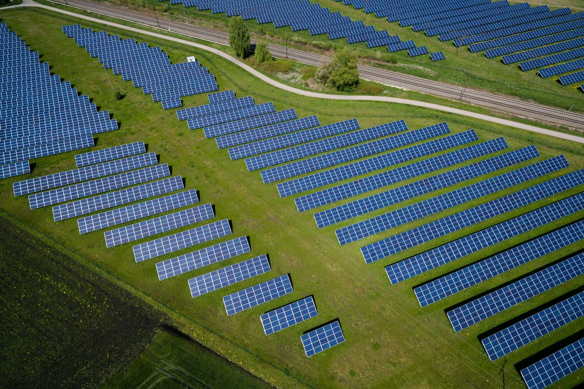 aerial photography of grass field with solar panels in rows.