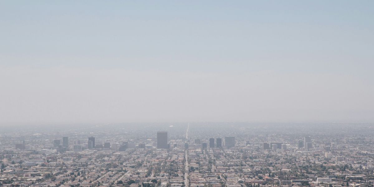 aerial view of city buildings during daytime with smog in the background.