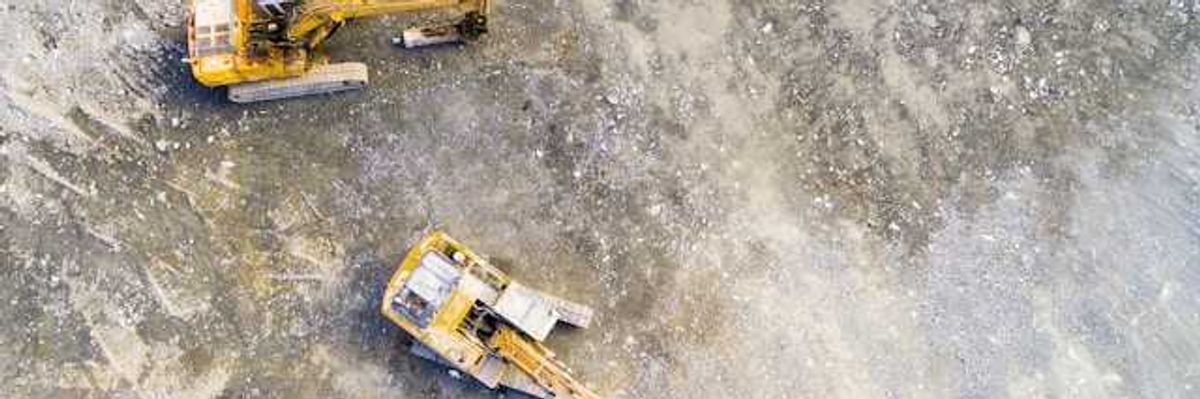 Aerial view of mining equipment on bare grey earth