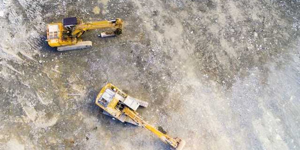 Aerial view of mining equipment on bare grey earth