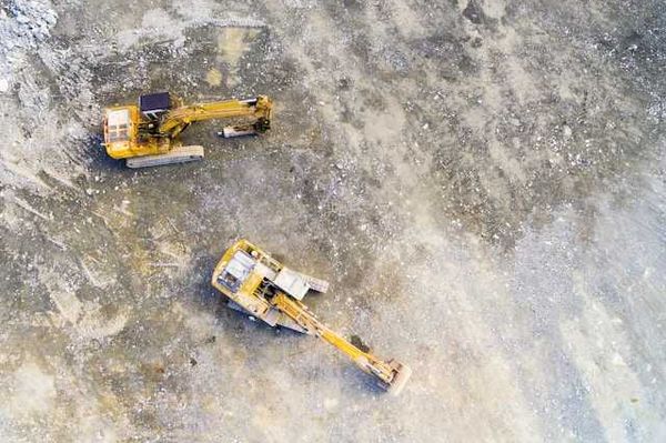 Aerial view of mining equipment on bare grey earth