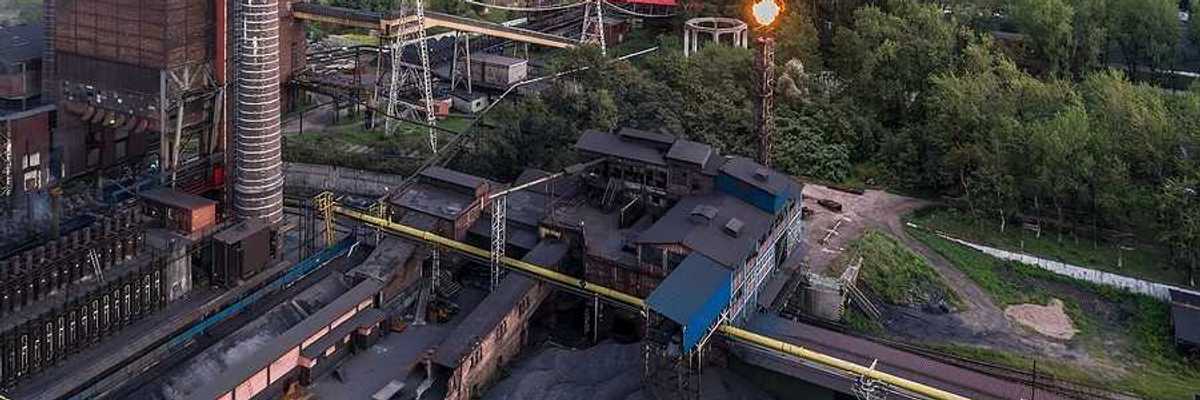 Aerial view on old working coking plant. Smokestacks, coal waste, flaring in progress.