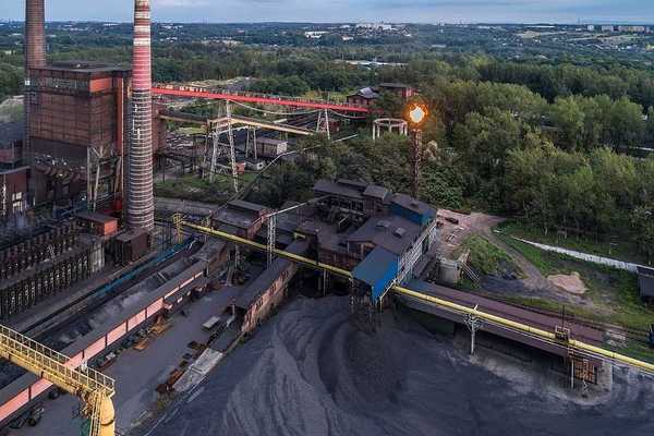 Aerial view on old working coking plant. Smokestacks, coal waste, flaring in progress.