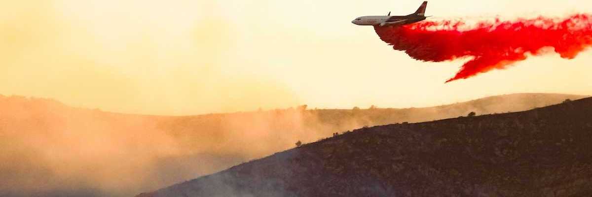 Aircraft drops fire retardant on a wildfire