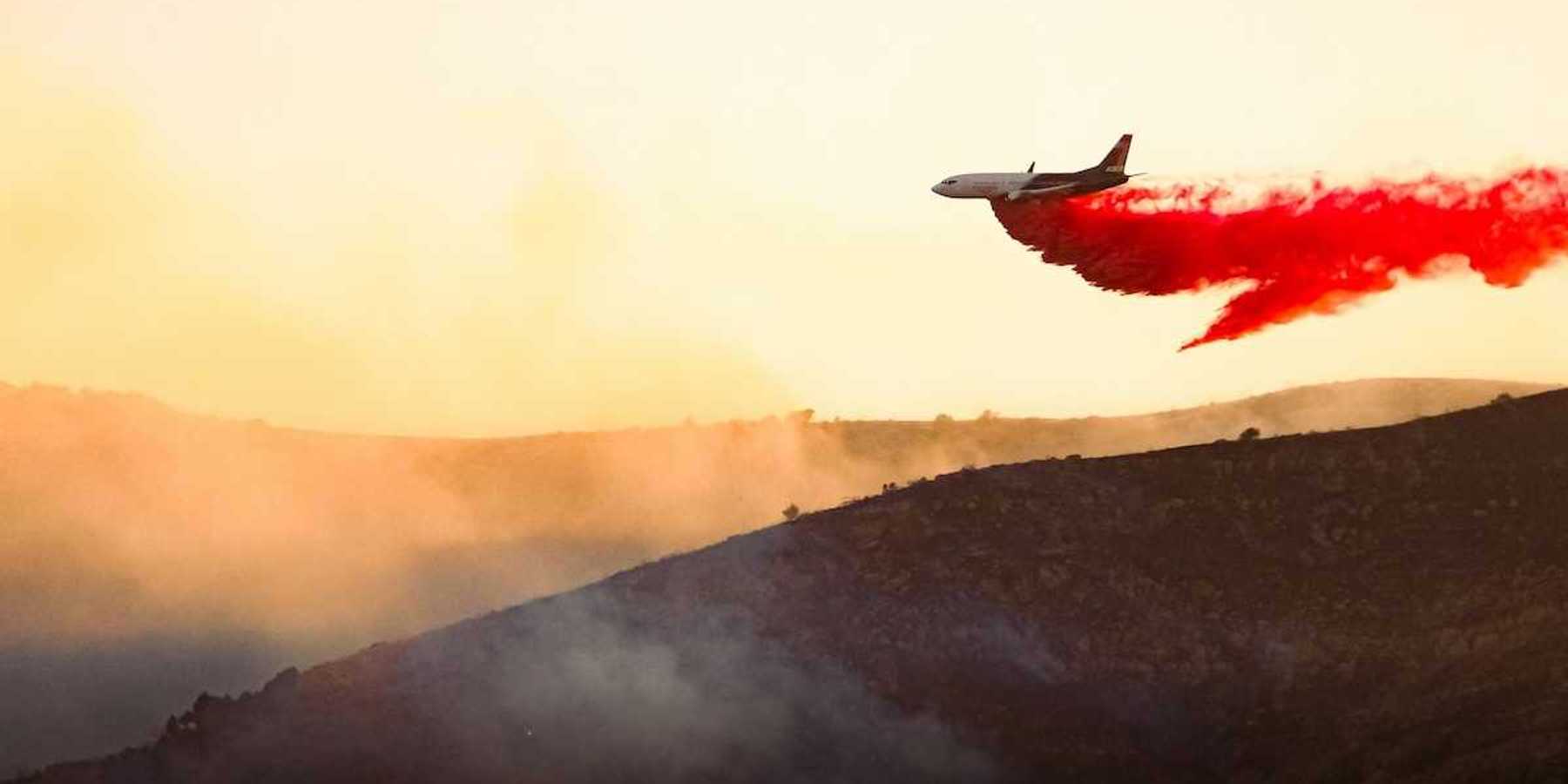 Aircraft drops fire retardant on a wildfire