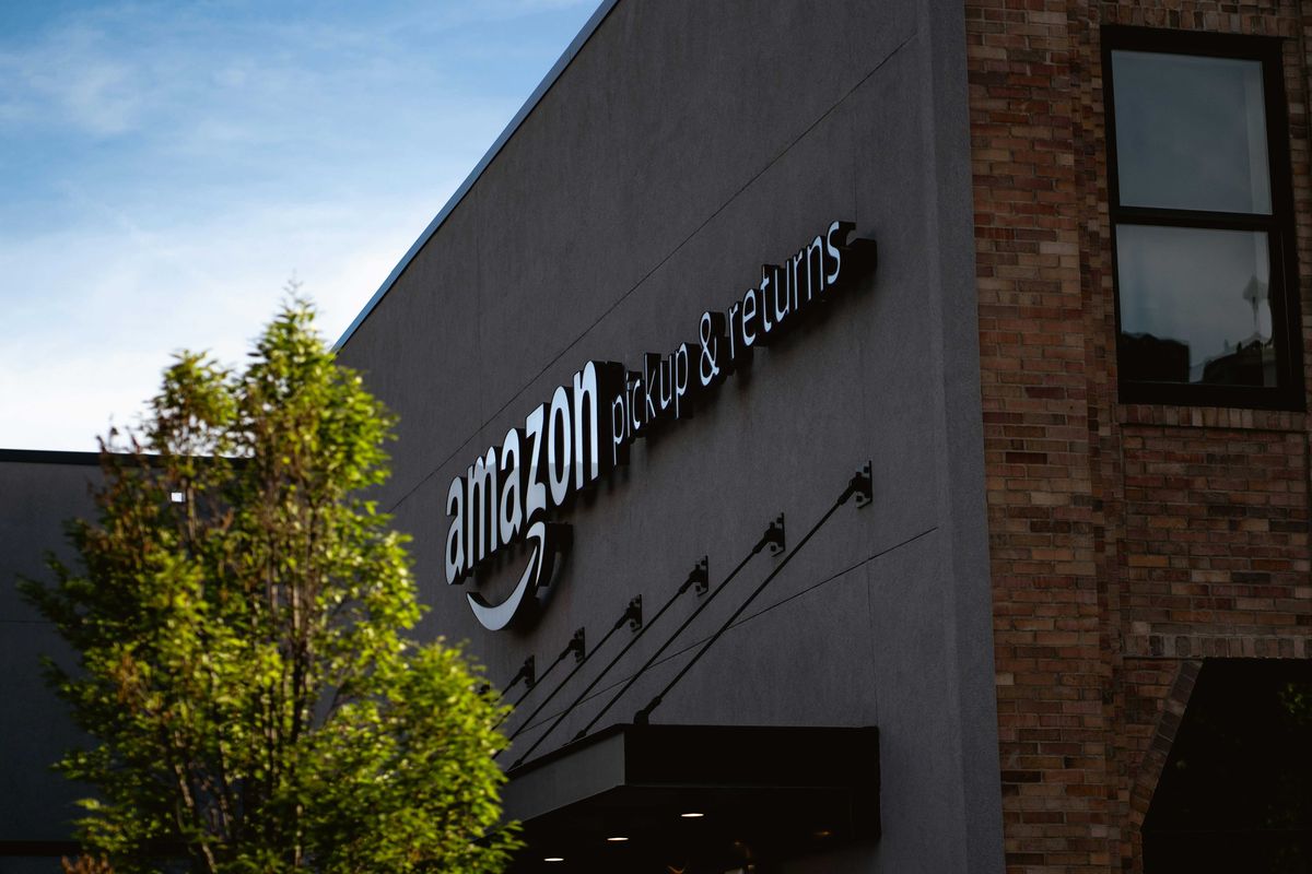 Amazon pickup & returns building next to a tree.