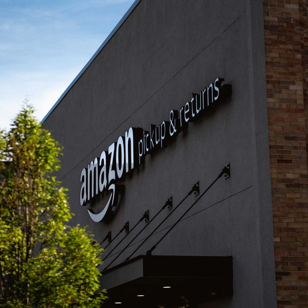 Amazon pickup & returns building next to a tree.