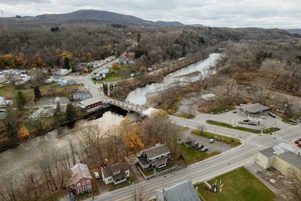 An aerial view of a new england town bisected by a river