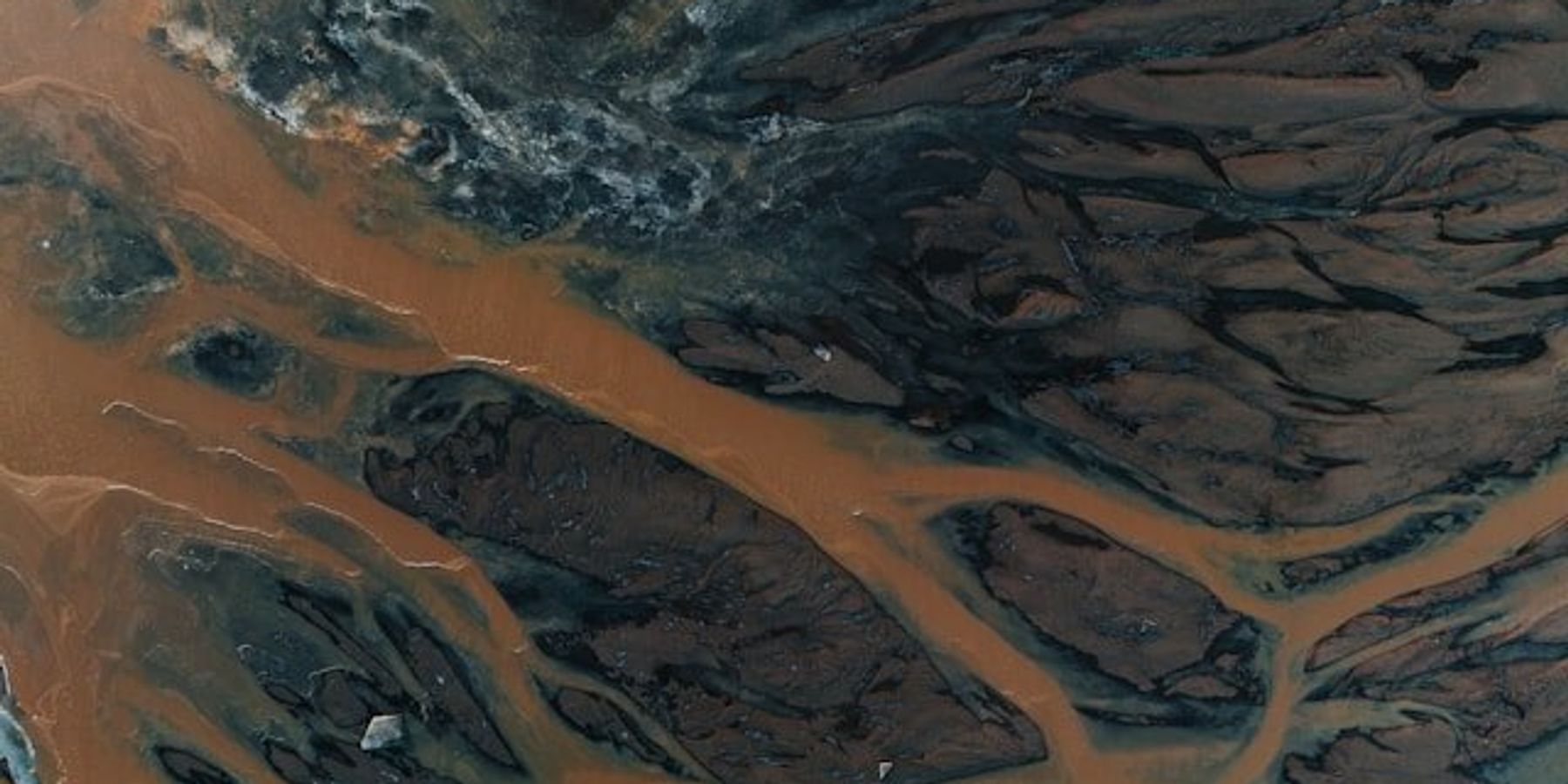 An aerial view of a river system with brown water.