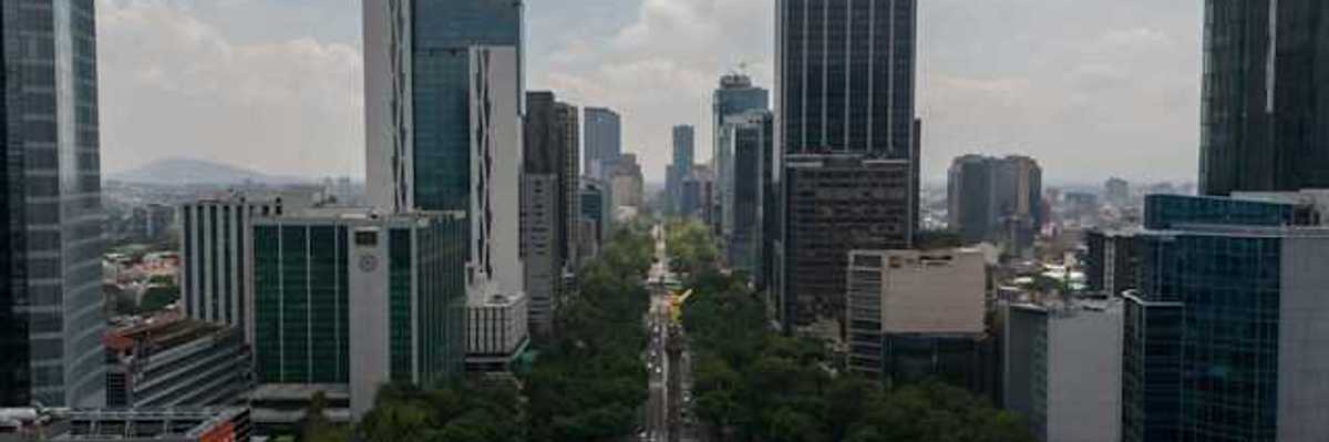 An aerial view of a roundabout with tall city buildings in the background