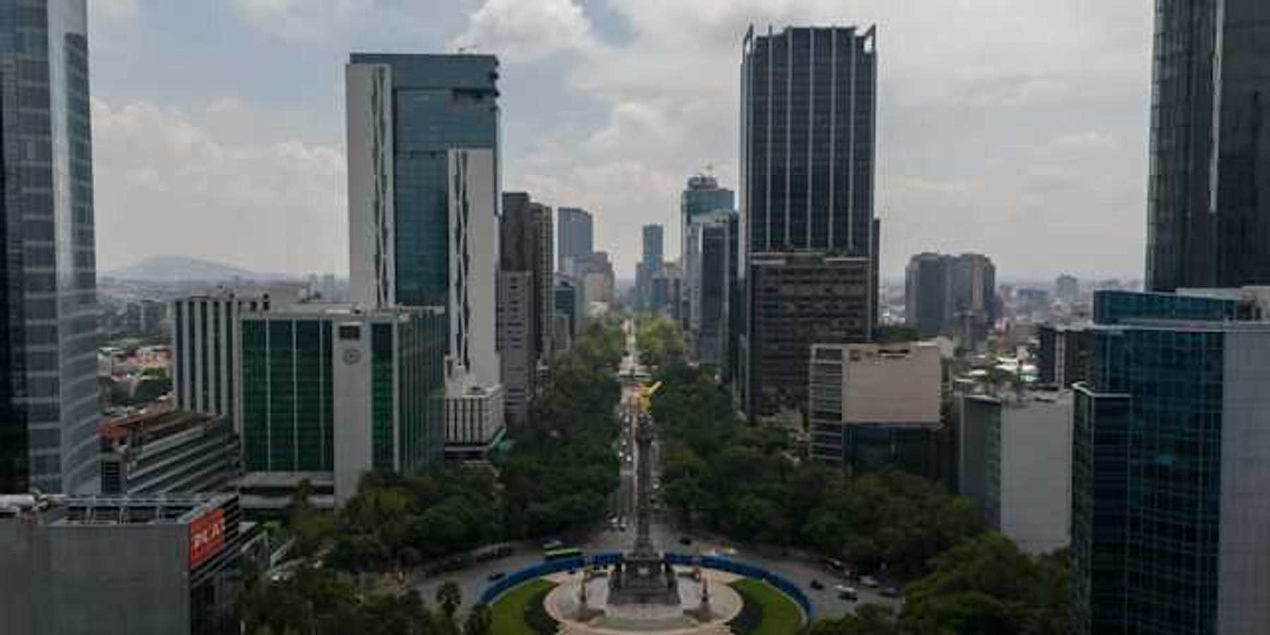 An aerial view of a roundabout with tall city buildings in the background