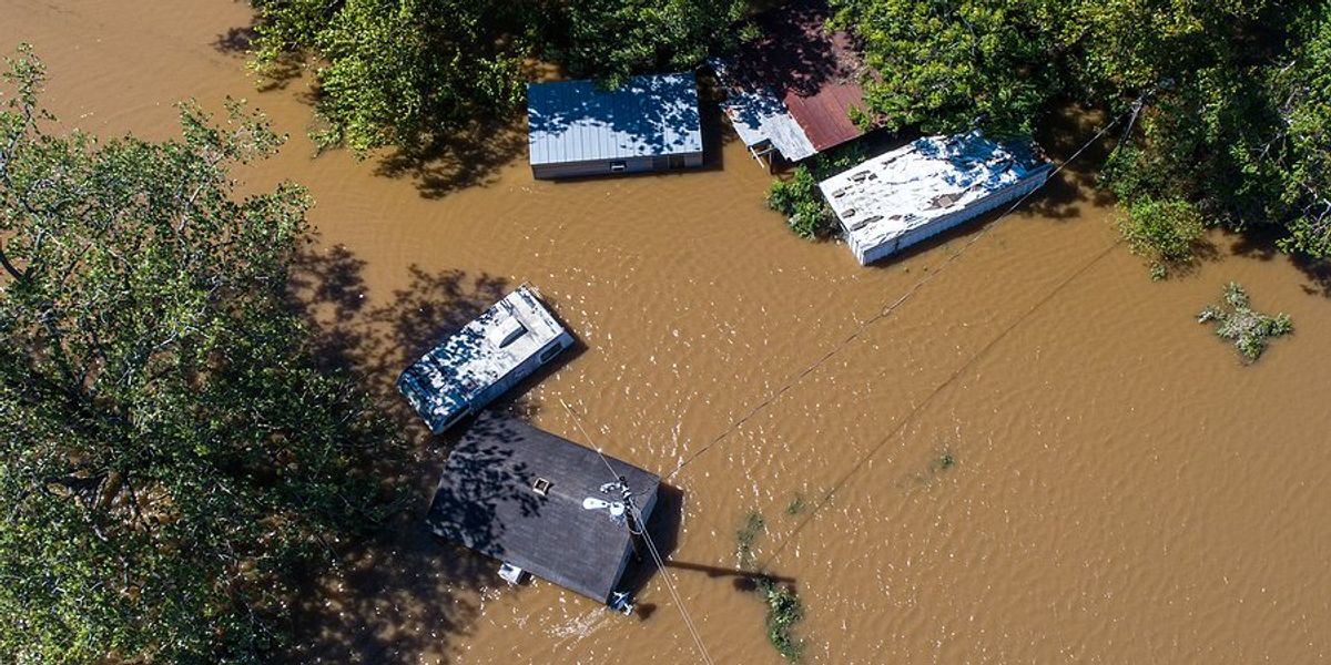 An aerial view of houses and structures under flood water.