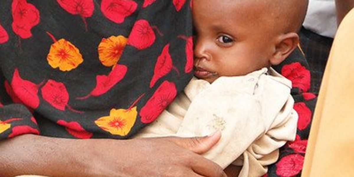 An African child being cradled in its mother's arms.