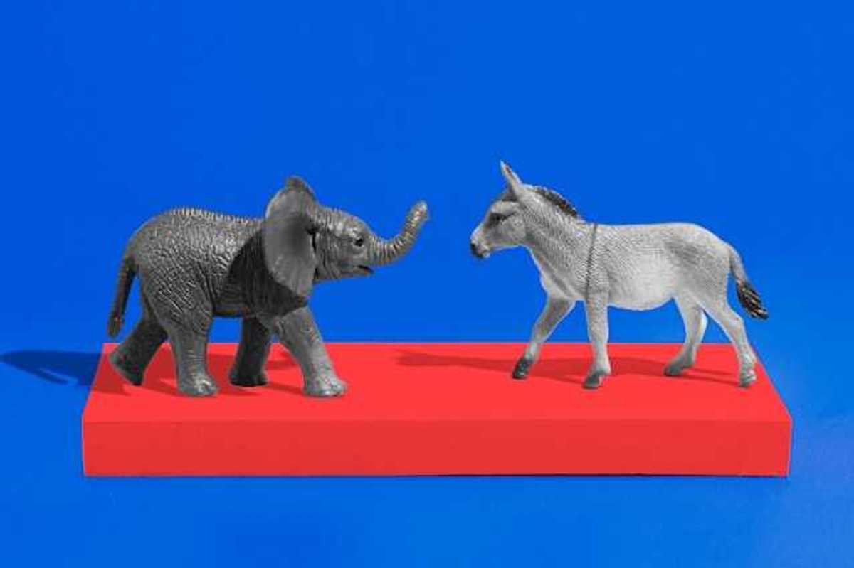 An elephant and a donkey figurine on a red platform with a blue background