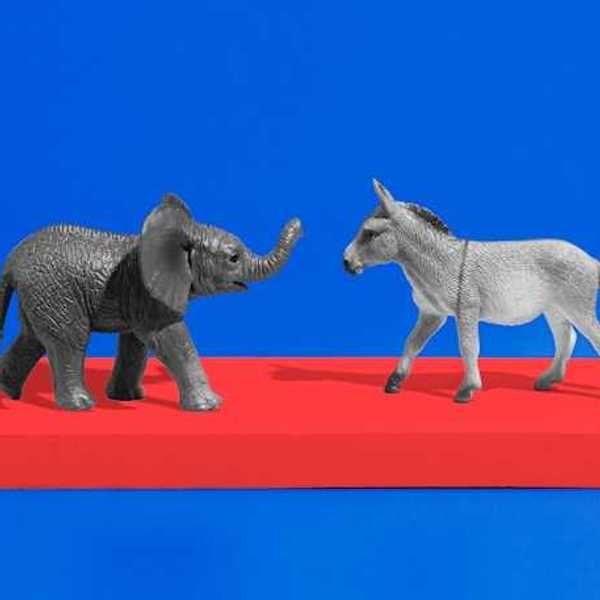 An elephant and a donkey figurine on a red platform with a blue background