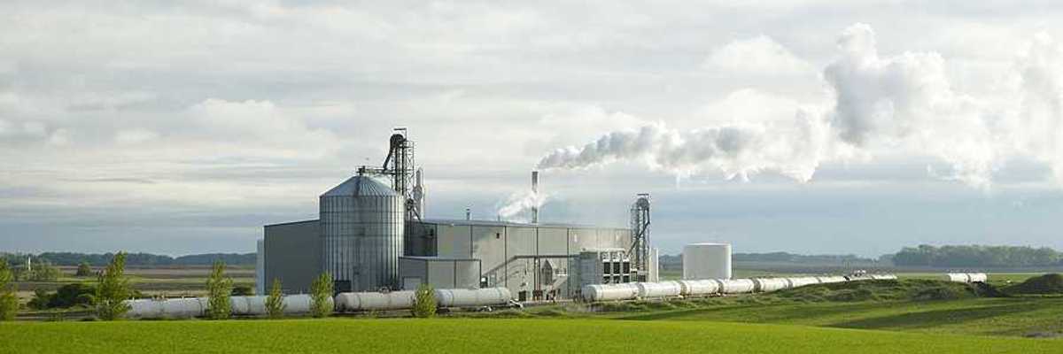 An ethanol plant with green fields in the foreground