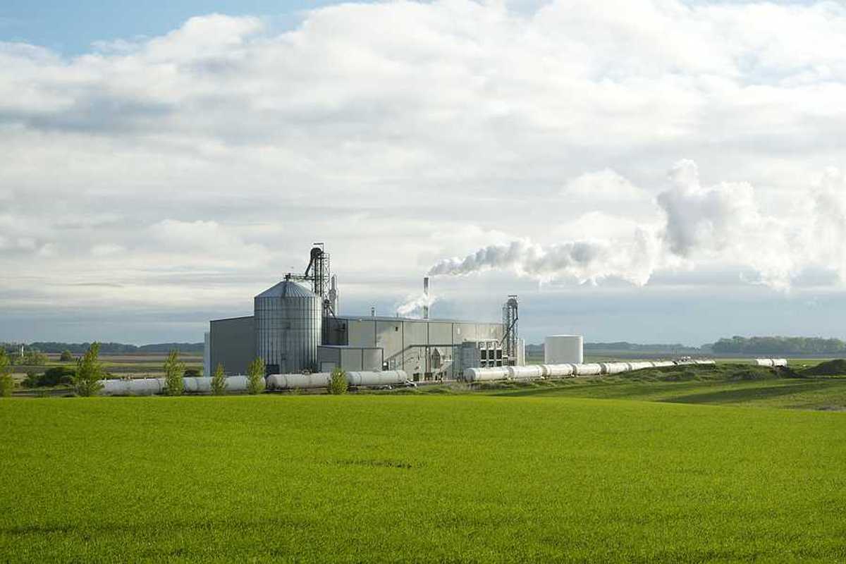 An ethanol plant with green fields in the foreground