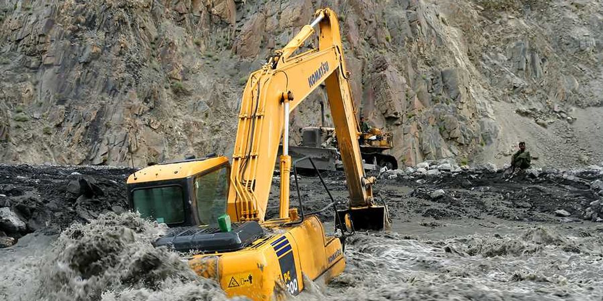An excavator sitting on a flooded road in Pakistan