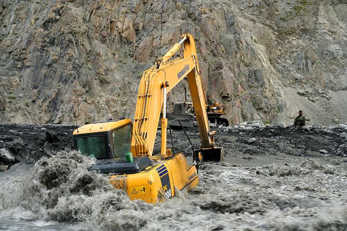 An excavator sitting on a flooded road in Pakistan