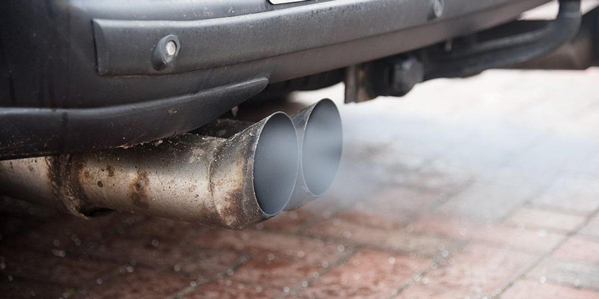 An exhaust pipe with smoke emitting from it.