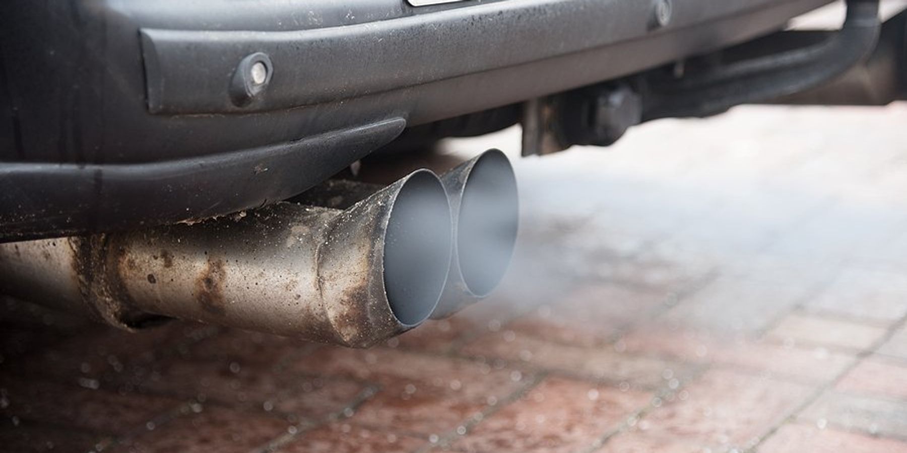 An exhaust pipe with smoke emitting from it.