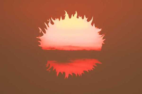An illustration of a burning sun falling below the horizon