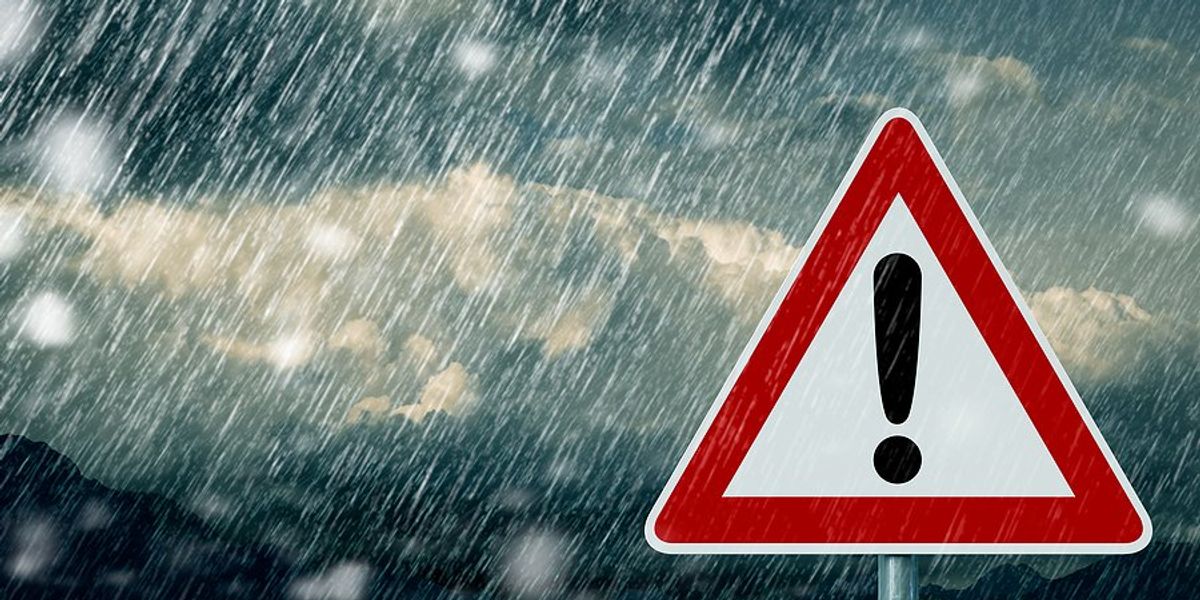 An image showing a downpour with a caution sign.