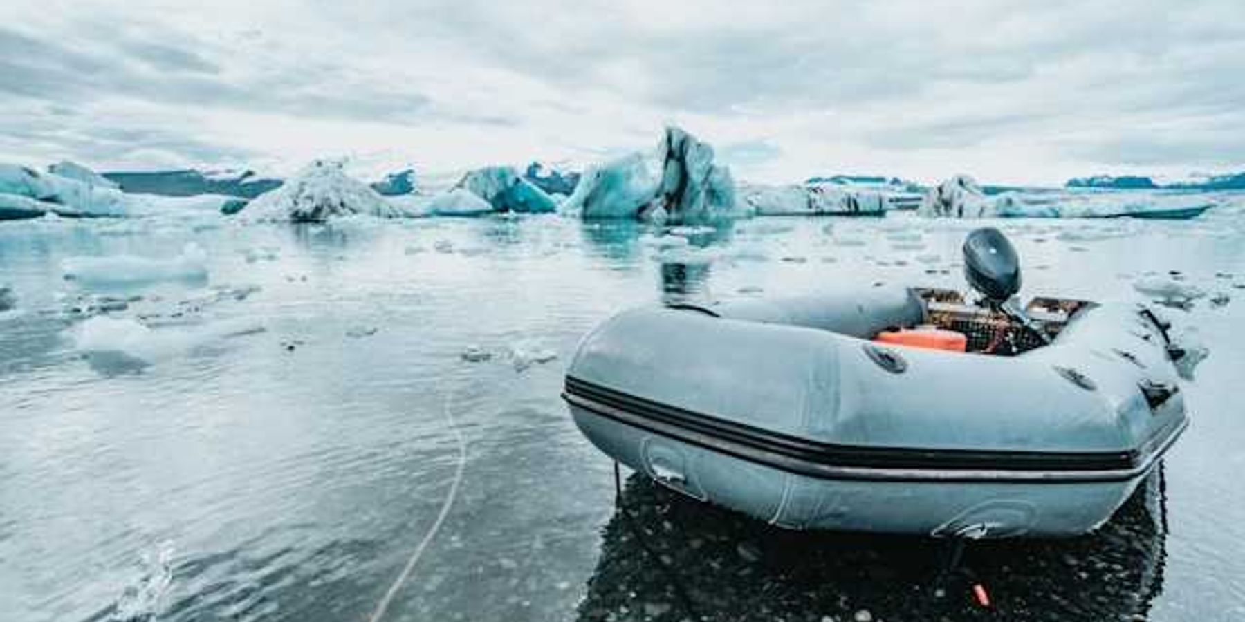 An inflatable boat pulled up to an icy shore