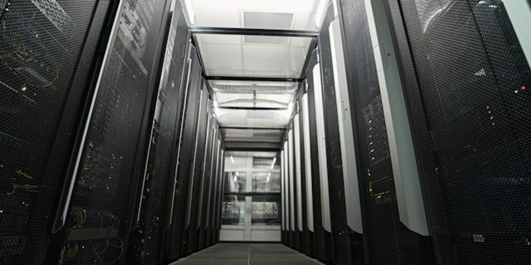An interior view of a data center with rows of servers visible.