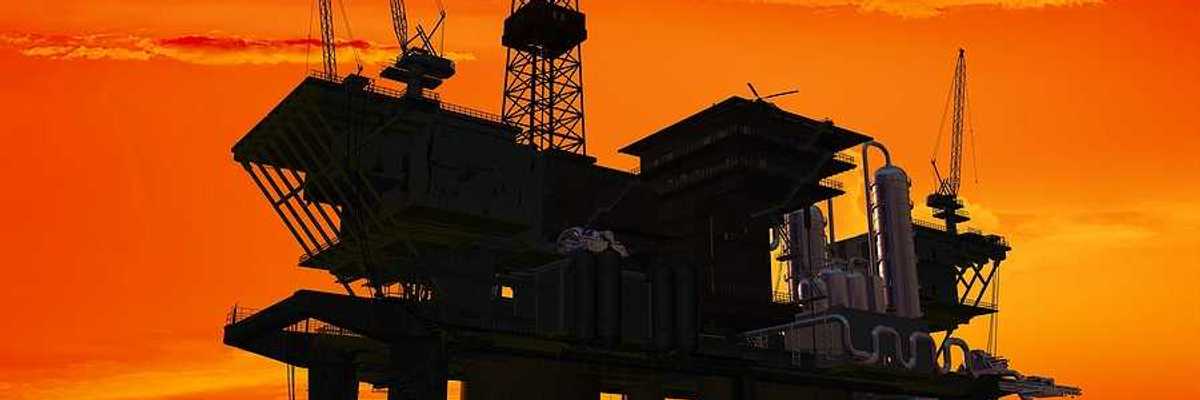 An offshore oil rig with the sunrise in the background