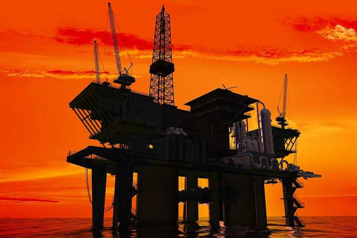 An offshore oil rig with the sunrise in the background