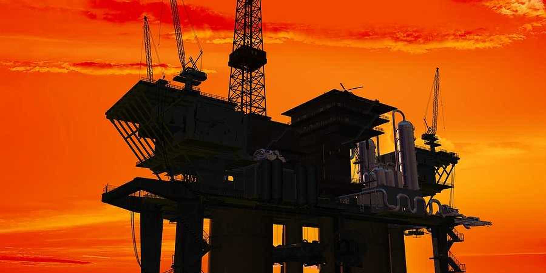 An offshore oil rig with the sunrise in the background