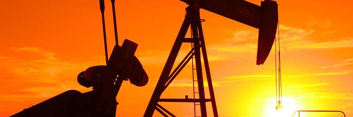 An oil drilling pump jack at sunset