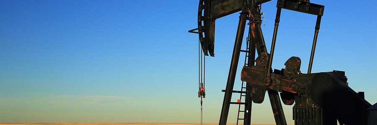 An oil pump jack in the middle of a dry field