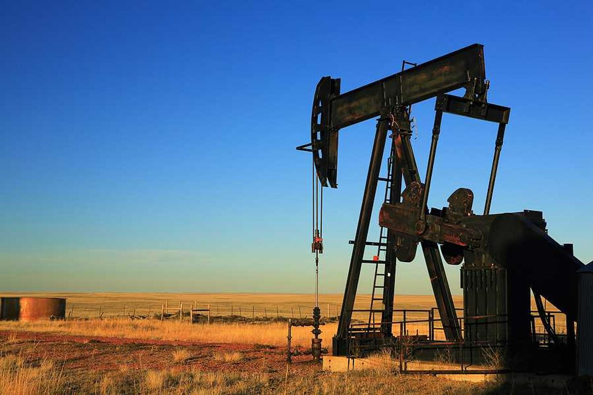 An oil pump jack in the middle of a dry field