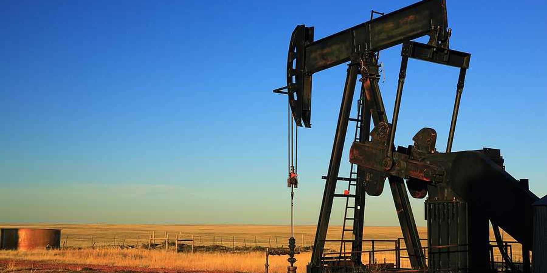 An oil pump jack in the middle of a dry field