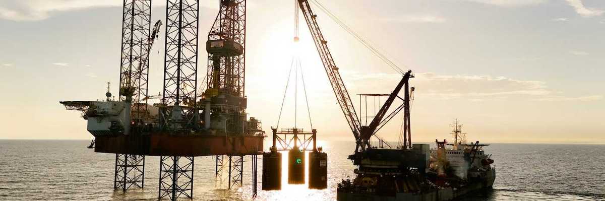 An oil rig being serviced by a supply ship