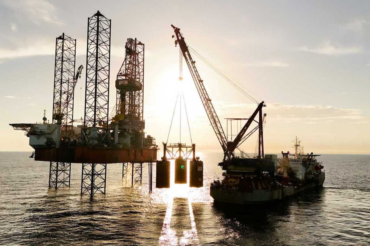 An oil rig being serviced by a supply ship