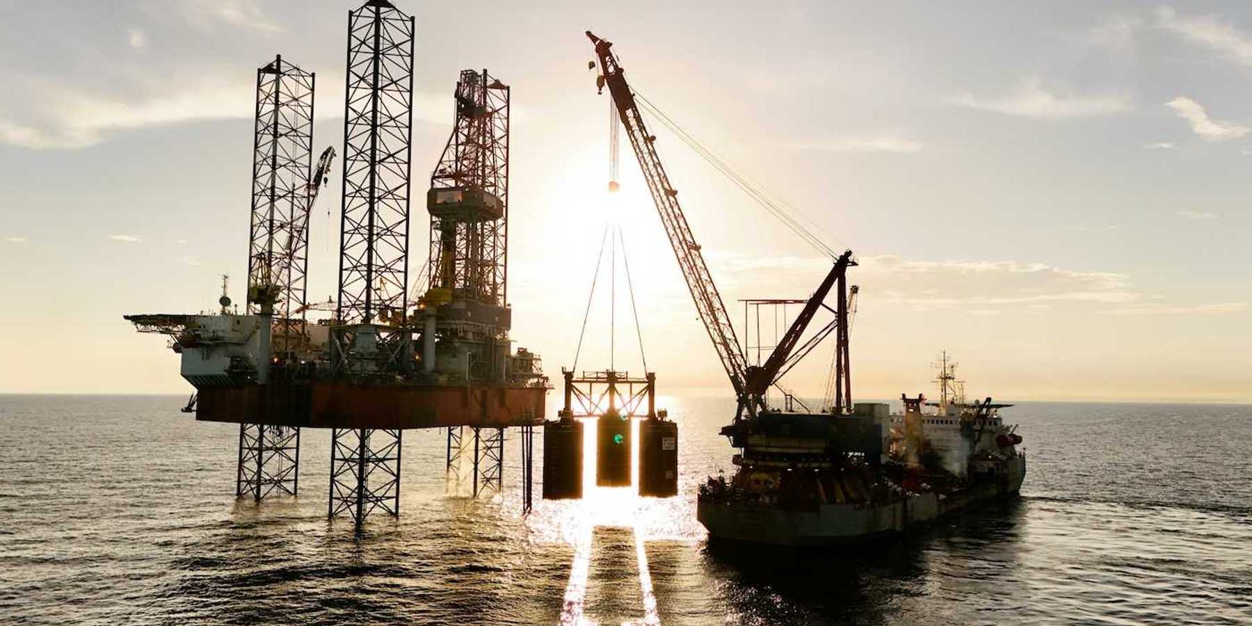 An oil rig being serviced by a supply ship