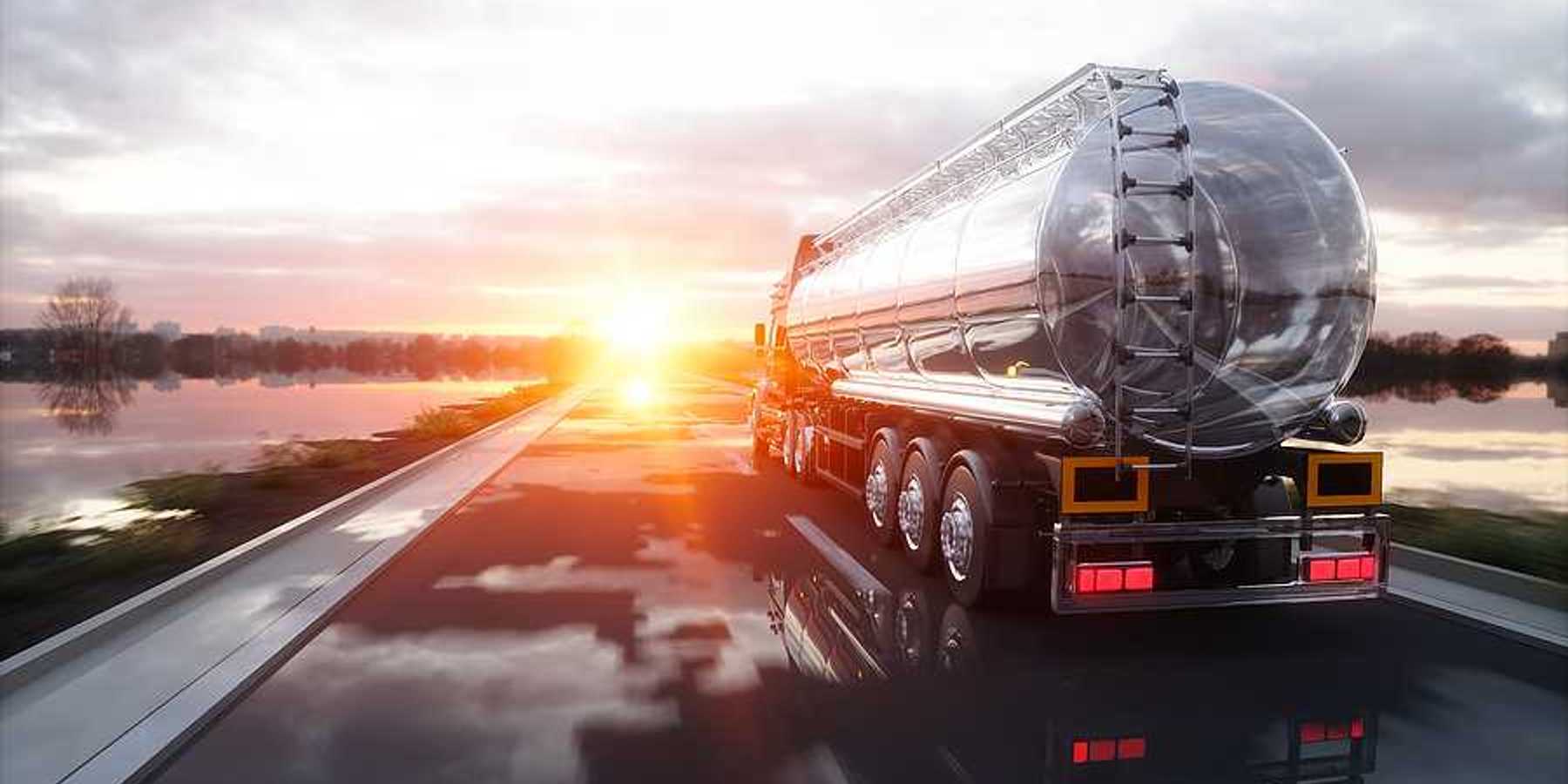 An oil tank truck driving down a highway