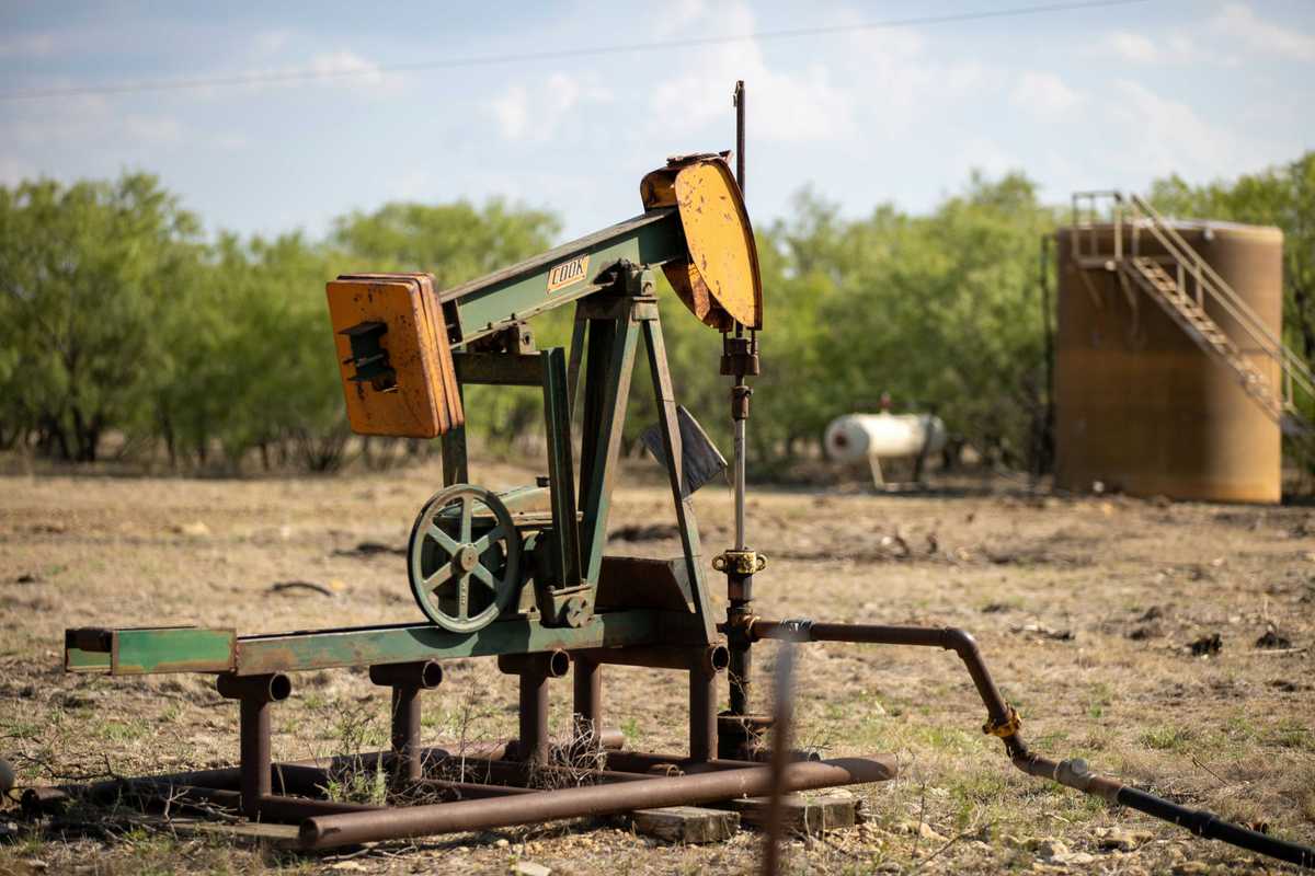 An old oil well pump jack in a field.
